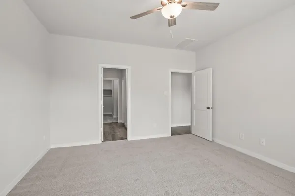 a view of an empty room with a chandelier fan