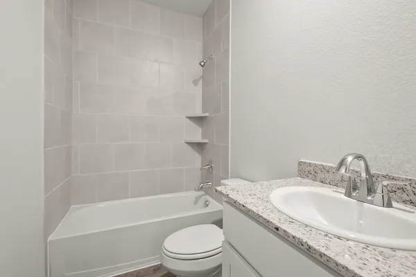 a bathroom with a granite countertop toilet a sink and a bathtub