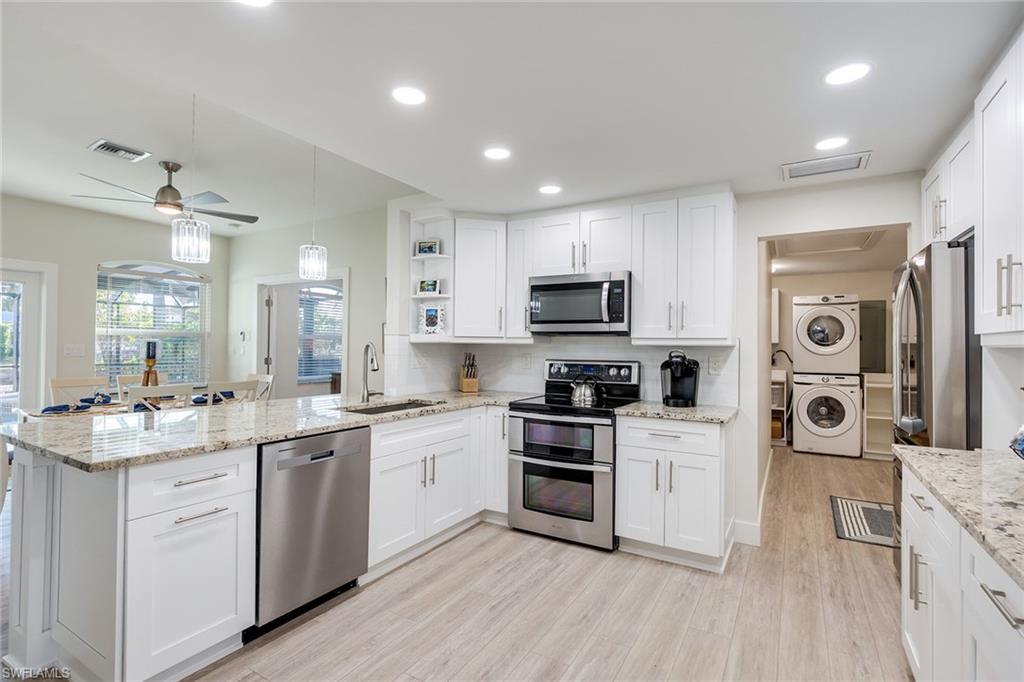 1410 Curlew Avenue Naples, FL 34102 - Photo 10 of 44 a kitchen with white cabinets stainless steel appliances and sink