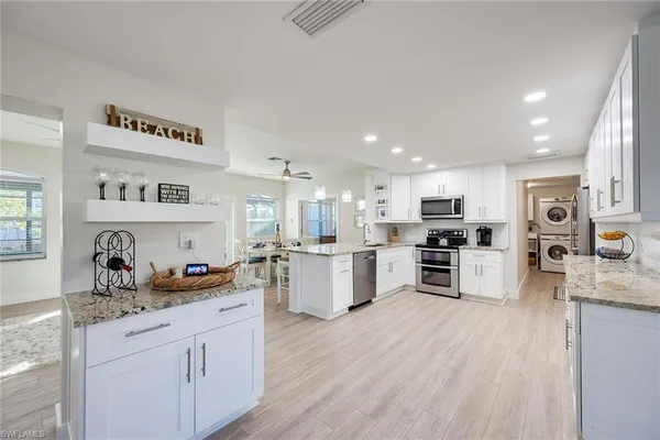 a kitchen with white cabinets stainless steel appliances and sink