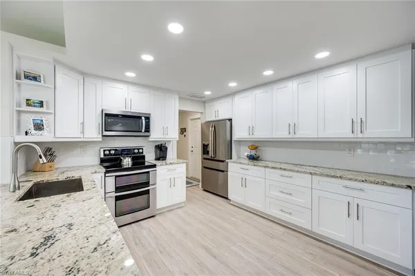 a kitchen with a stove top oven sink and cabinets