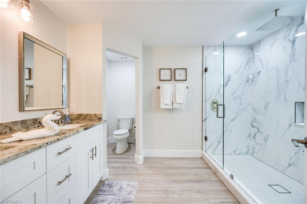 1410 Curlew Avenue Naples, FL 34102 - Photo 19 of 44 a spacious bathroom with a granite countertop sink a toilet and shower