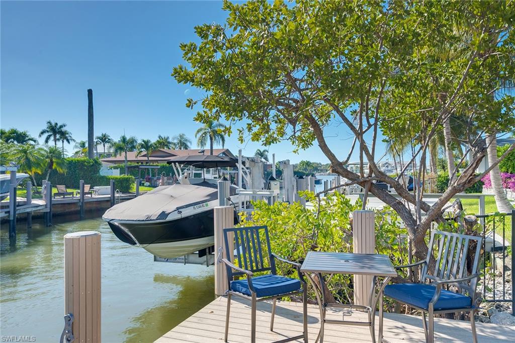 1410 Curlew Avenue Naples, FL 34102 - Photo 38 of 44 a view of house with outdoor seating and lake