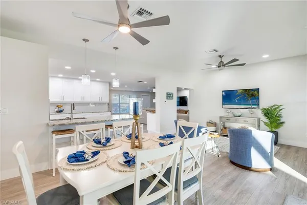 a kitchen with stainless steel appliances kitchen island granite countertop a table chairs and a refrigerator