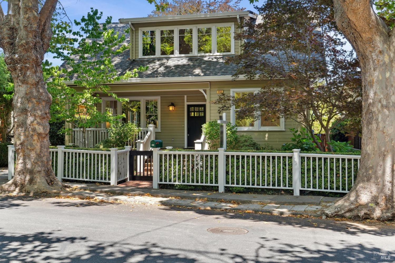 a view of a house with a garden and trees