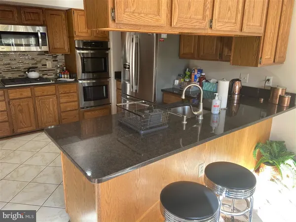a kitchen with stainless steel appliances granite countertop a sink a stove and refrigerator