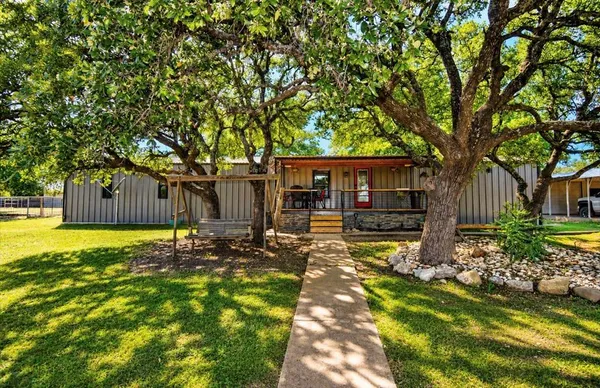a view of a house with garden and trees