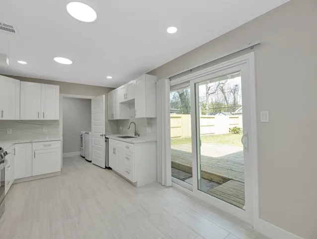 a kitchen with white cabinets and white appliances