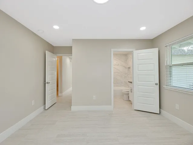 a view of an empty room with closet and utility room