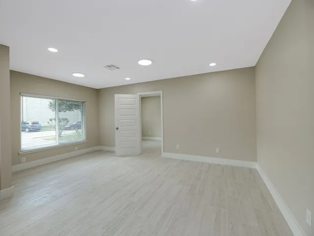 an empty room with window and wooden floor