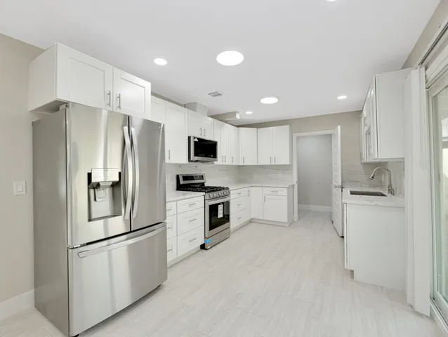 a kitchen with stainless steel appliances a refrigerator sink and microwave