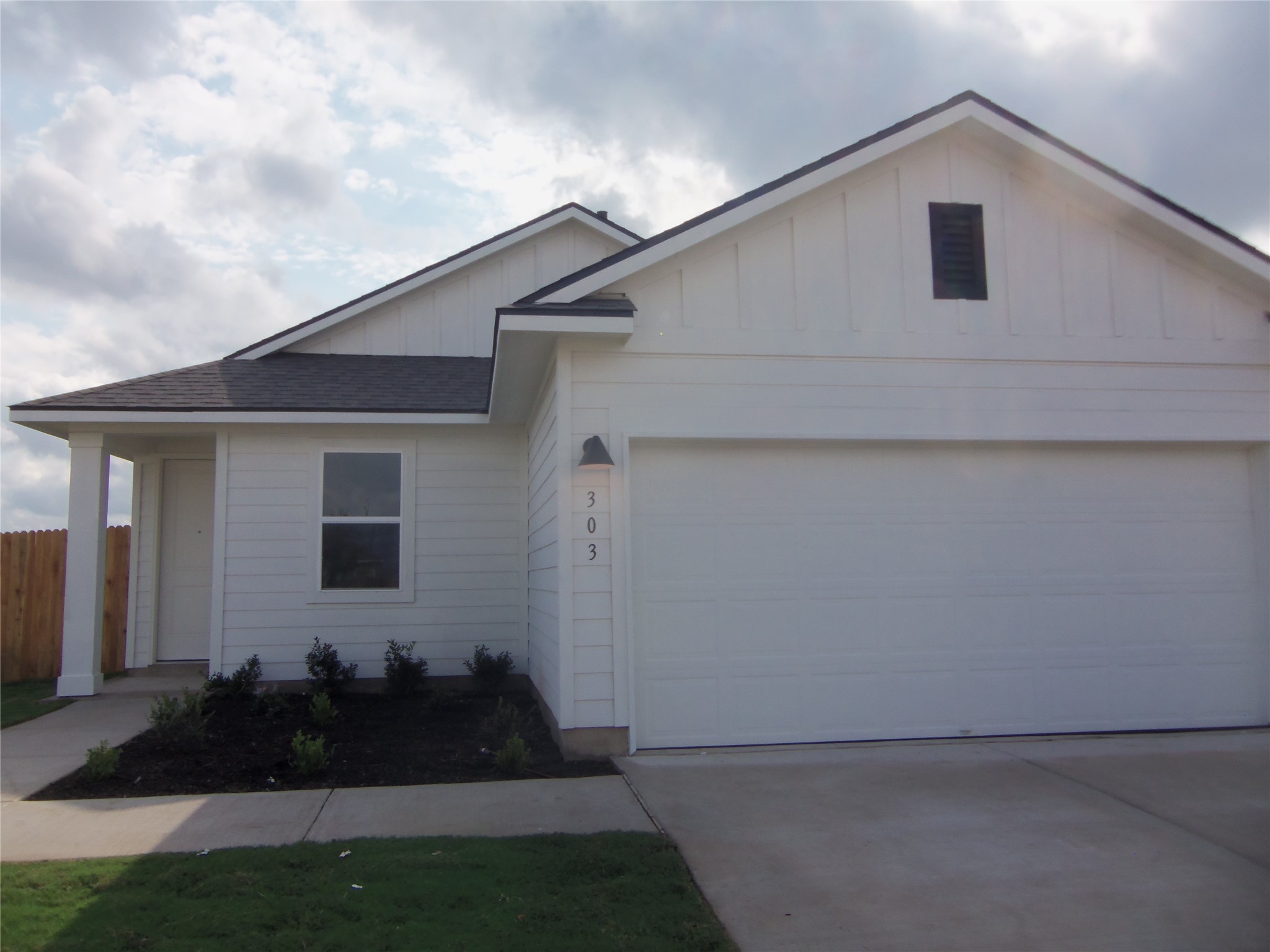 A well-maintained facade with a two-car garage awaits, showcasing meticulous landscaping and a welcoming entrance.