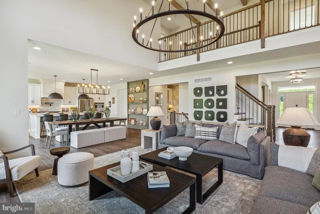 a living room with furniture kitchen view and a chandelier