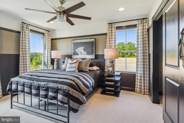 a bedroom with a bed chairs and a window