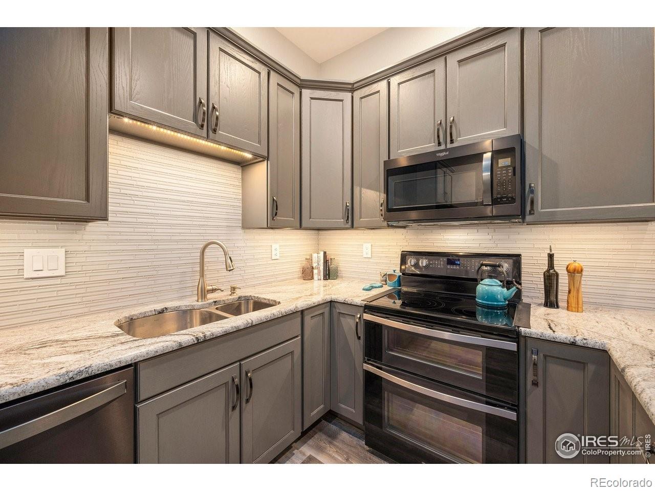 4500 Seneca Street, Unit 66 Fort Collins, CO 80526 - Photo 12 of 20 a kitchen with stainless steel appliances a stove sink microwave and cabinets