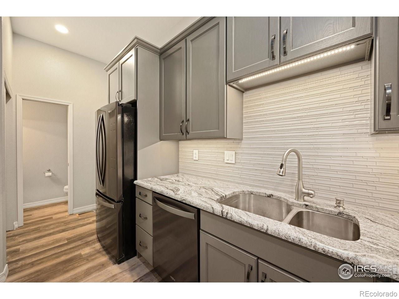 4500 Seneca Street, Unit 66 Fort Collins, CO 80526 - Photo 13 of 20 a kitchen with stainless steel appliances granite countertop a sink refrigerator and cabinets