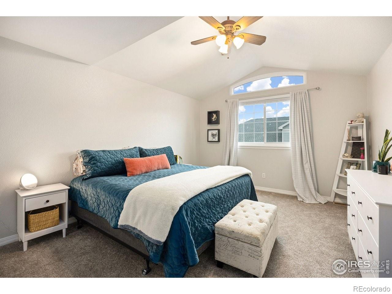 4500 Seneca Street, Unit 66 Fort Collins, CO 80526 - Photo 14 of 20 a bedroom with a bed next to a window and a chandelier