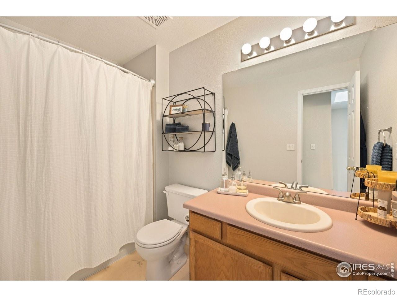 4500 Seneca Street, Unit 66 Fort Collins, CO 80526 - Photo 15 of 20 a bathroom with a sink vanity mirror and toilet