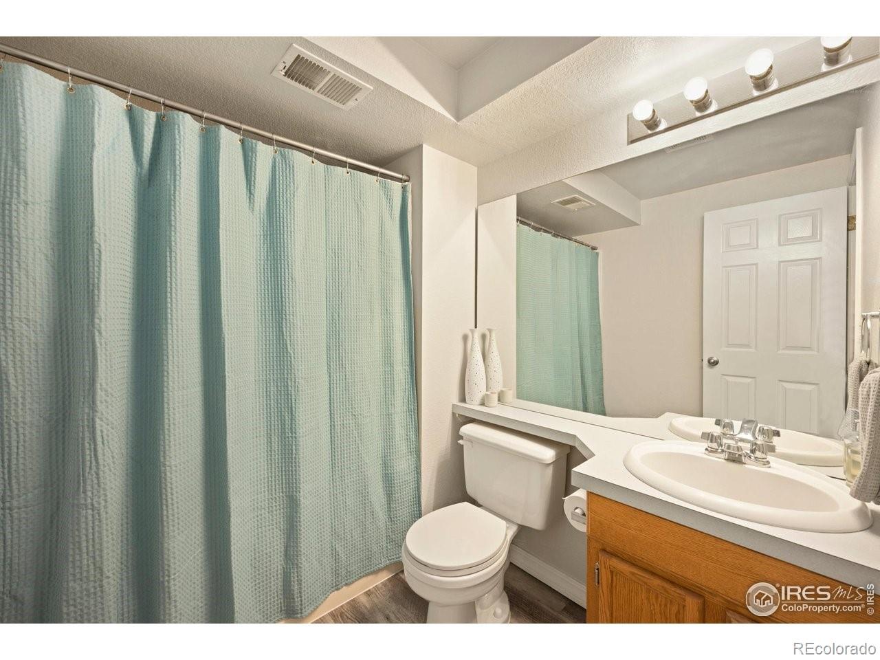 4500 Seneca Street, Unit 66 Fort Collins, CO 80526 - Photo 19 of 20 a bathroom with a granite countertop sink toilet and a mirror