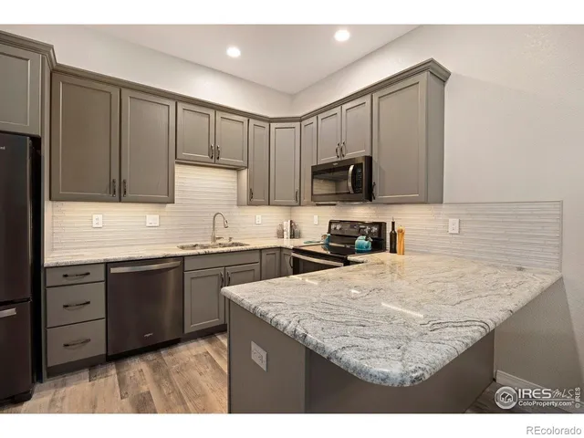 a kitchen with kitchen island granite countertop a sink stove and refrigerator