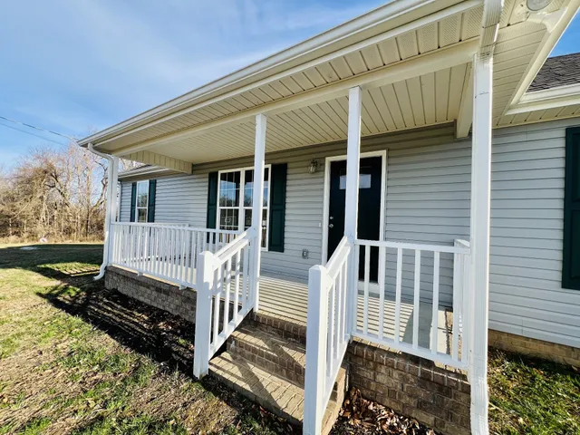 a view of a house with wooden fence and a porch