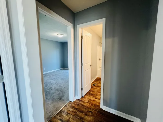 a view of a hallway with wooden floor and staircase