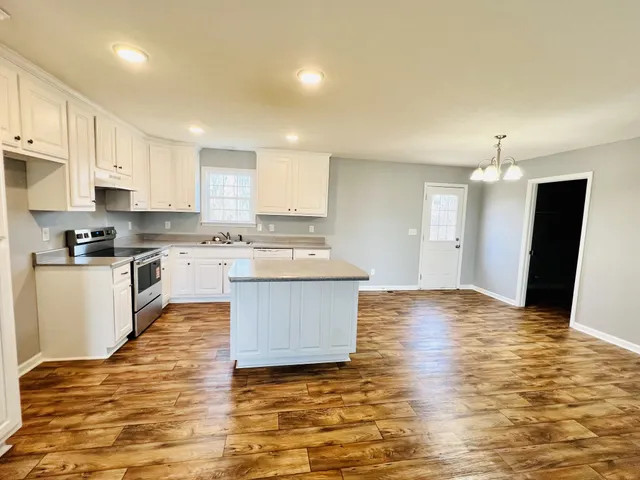 a large kitchen with kitchen island a sink a stove and refrigerator