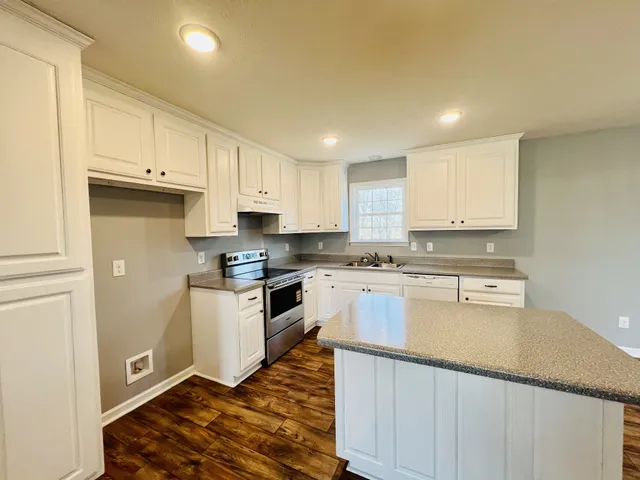a kitchen with granite countertop white cabinets and white appliances