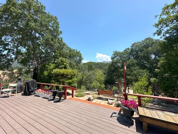a view of a patio with table and chairs a barbeque with wooden fence and floor
