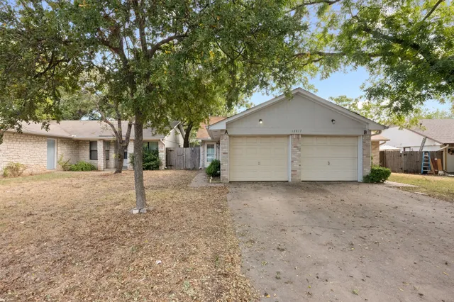 a view of a house with a tree and garage