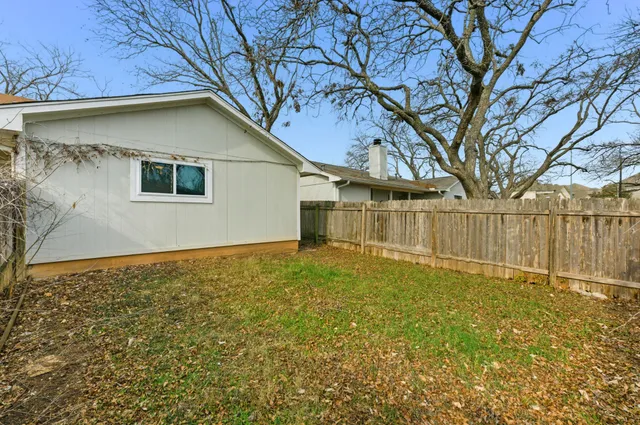 a backyard of a house with plants and tree