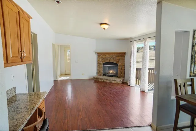 a view of a livingroom with wooden floor and a fireplace
