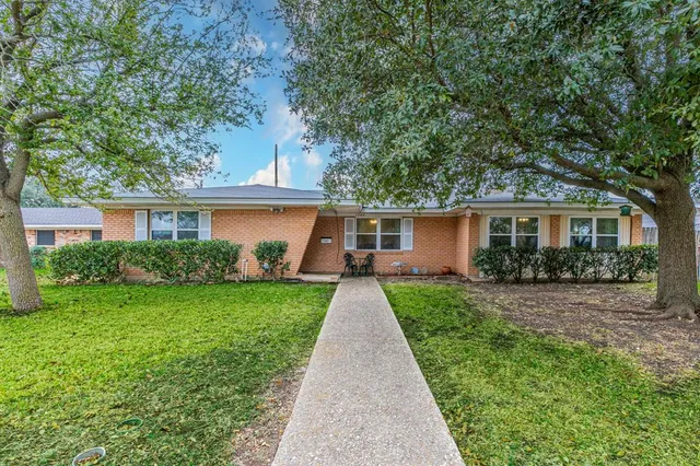 front view of a house and a yard with potted plants
