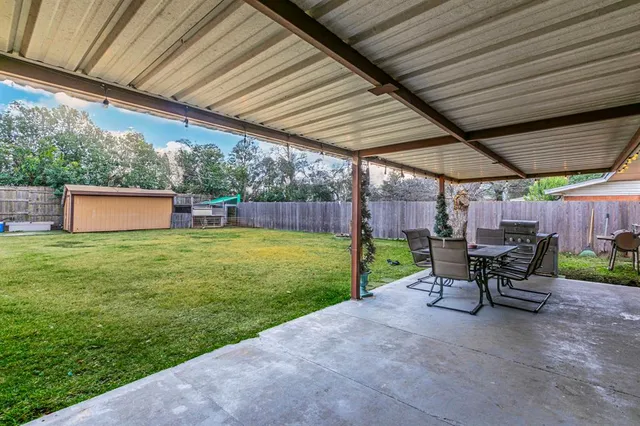 a view of a patio with table and chairs with wooden fence and plants