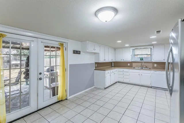 a large kitchen with a white stove top oven and white cabinets