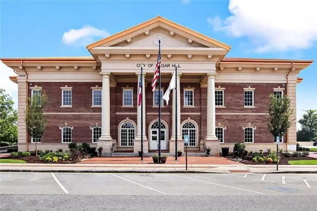 a front view of a house with garden and sitting area