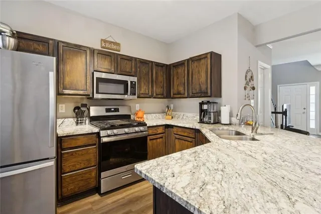 a kitchen with stainless steel appliances granite countertop a refrigerator stove microwave and sink