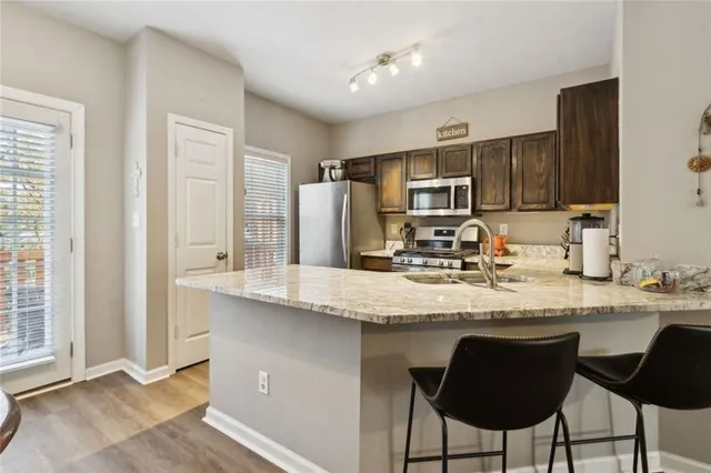 a kitchen with granite countertop a sink cabinets and stainless steel appliances