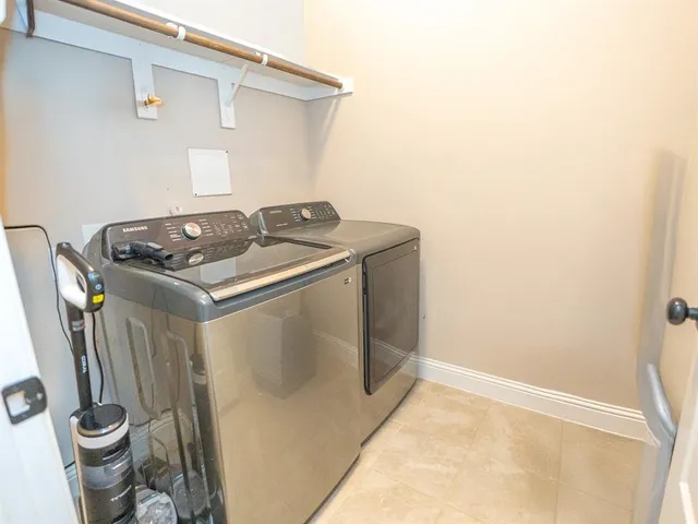 a utility room with water heater and white cabinets