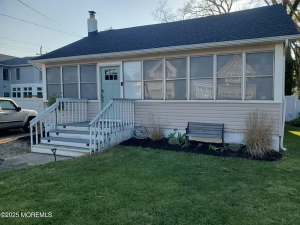 a view of a house with a small yard and wooden fence