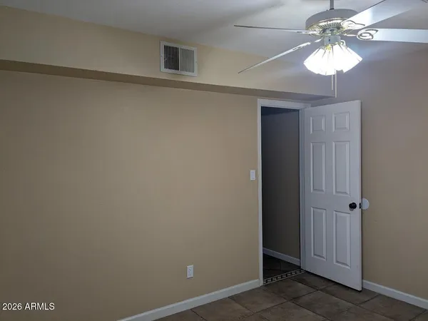 an empty room with a chandelier fan