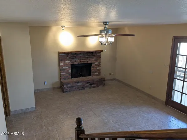 wooden floor fireplace and windows in an empty room