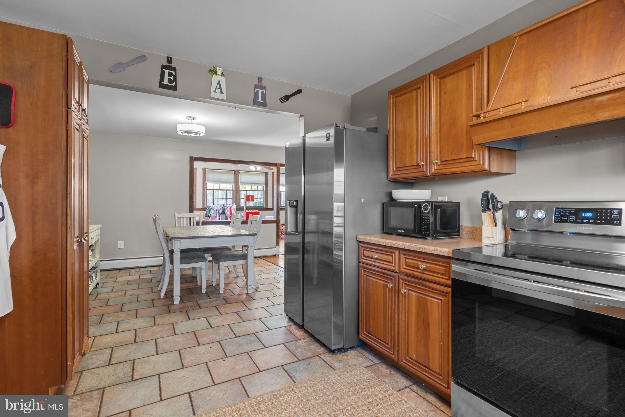 21 Downhill Road Levittown, PA 19056 - Photo 13 of 28 a kitchen with stainless steel appliances granite countertop a sink a stove a refrigerator cabinets and dining table