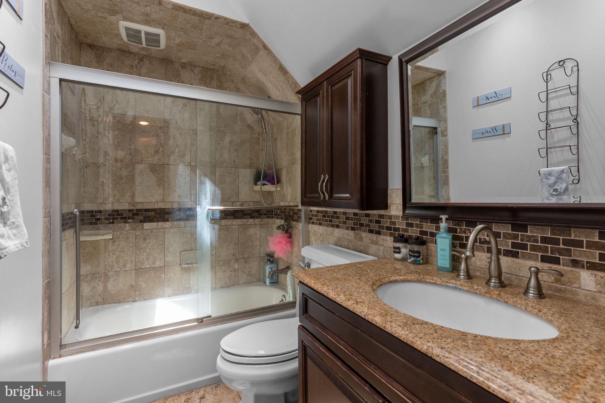 21 Downhill Road Levittown, PA 19056 - Photo 21 of 28 a bathroom with a granite countertop sink a toilet a mirror and shower