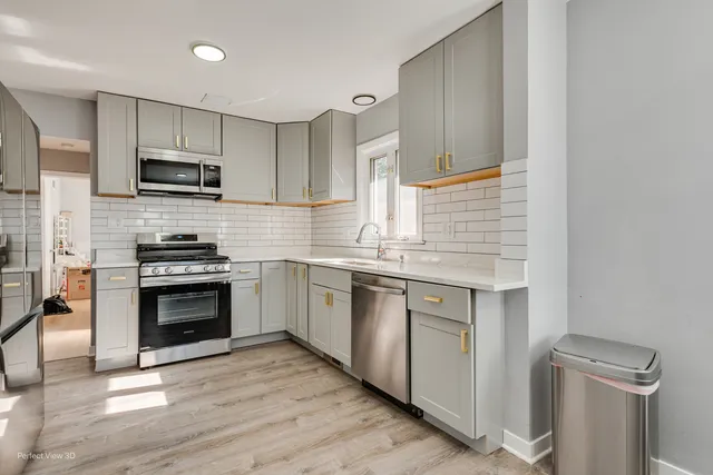 a kitchen with stainless steel appliances a stove sink microwave and cabinets