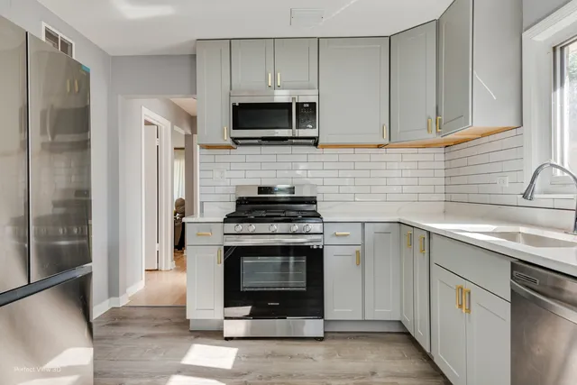 a kitchen with stainless steel appliances a stove a sink and a microwave