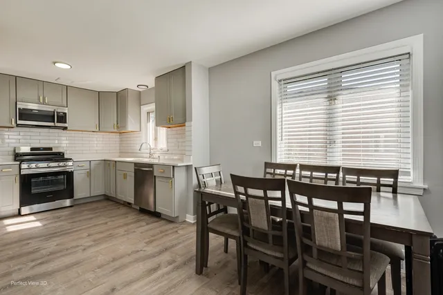 a kitchen with a table chairs sink and microwave