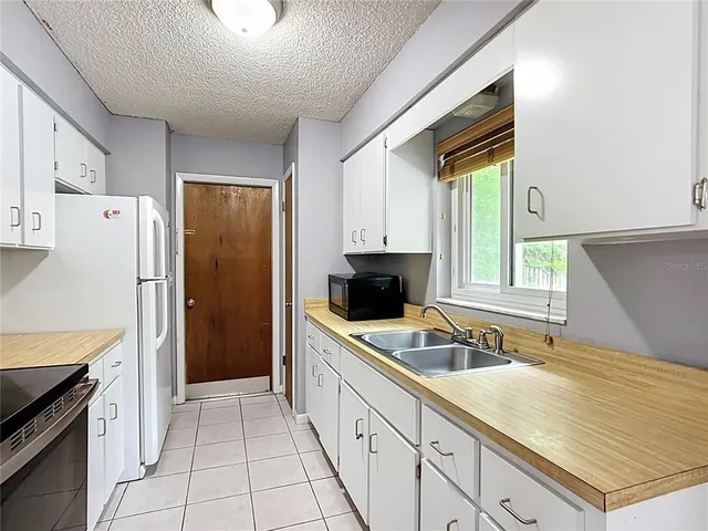 a kitchen with stainless steel appliances a refrigerator sink and cabinets