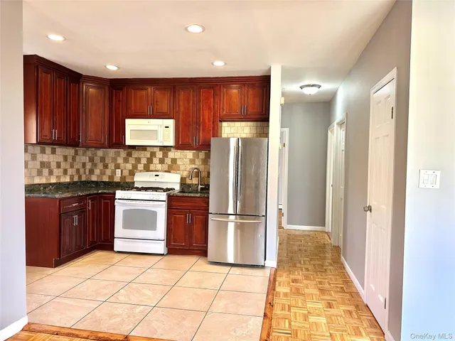 a kitchen with stainless steel appliances granite countertop a refrigerator and a stove top oven