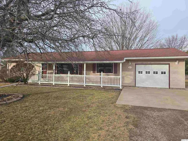 a front view of a house with a garden and trees